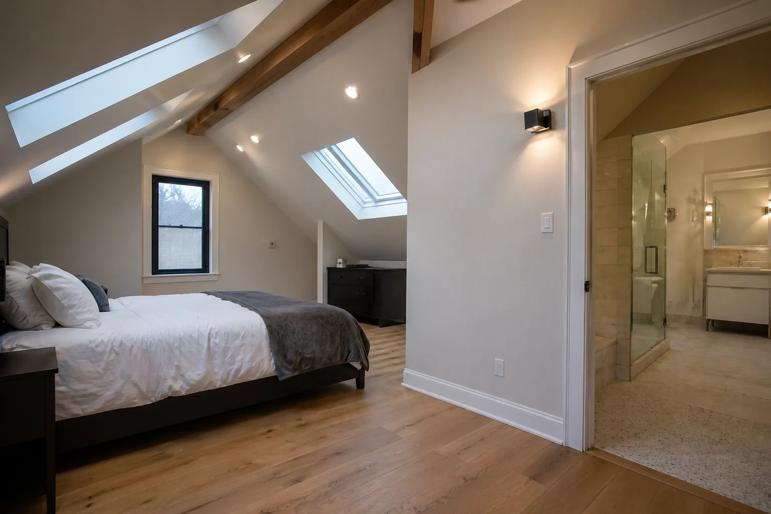 Attic primary bedroom Ottawa with sloped ceiling and skylights